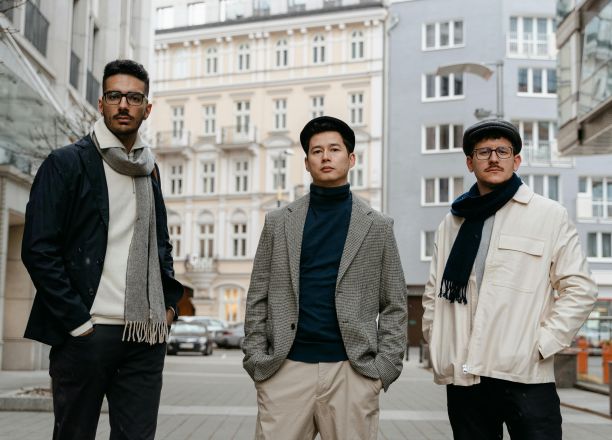 Stylish men posing confidently in an urban street setting, showcasing modern fashion.